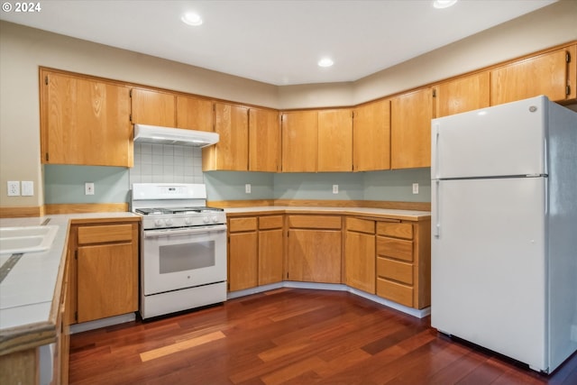 kitchen with dark hardwood / wood-style flooring, white appliances, and backsplash