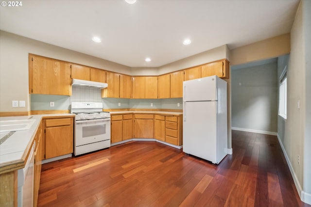 kitchen with white appliances, backsplash, and dark hardwood / wood-style flooring