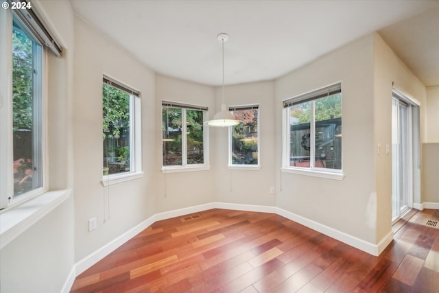 unfurnished dining area featuring hardwood / wood-style floors and a healthy amount of sunlight