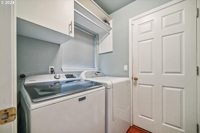 laundry room featuring washer and clothes dryer, cabinets, and hardwood / wood-style flooring