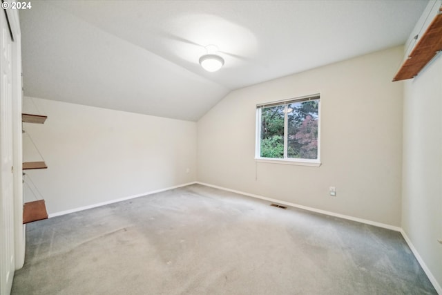 additional living space featuring carpet flooring and lofted ceiling