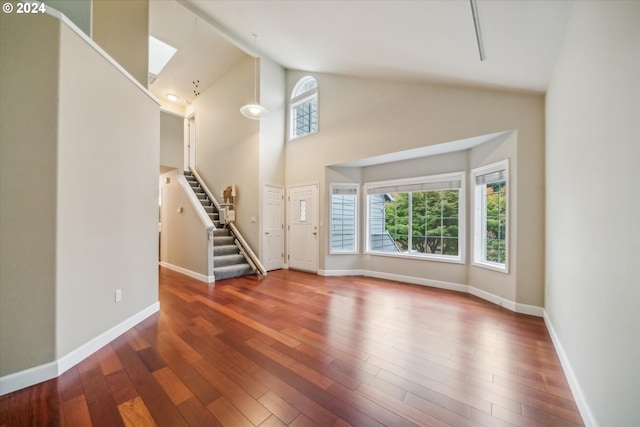 unfurnished living room featuring high vaulted ceiling and hardwood / wood-style floors