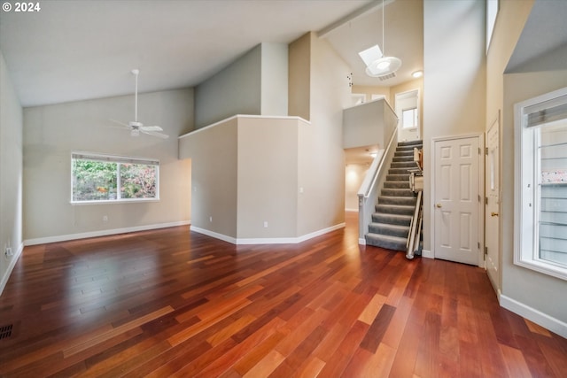 unfurnished living room with ceiling fan, dark hardwood / wood-style floors, and high vaulted ceiling