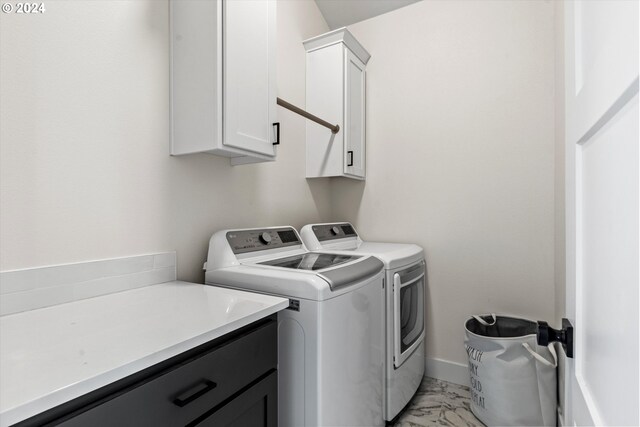 washroom with washing machine and clothes dryer, cabinets, and light tile patterned floors