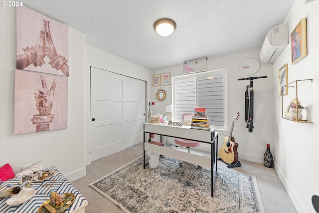 carpeted office space featuring a wall unit AC and a textured ceiling