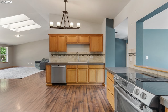 kitchen with dark wood-type flooring, stainless steel appliances, tasteful backsplash, sink, and lofted ceiling with skylight