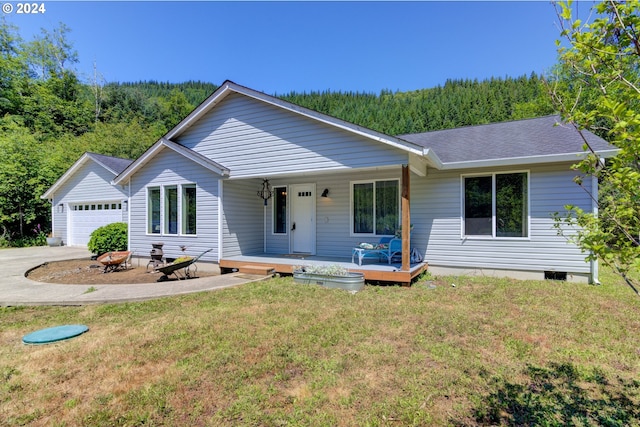 single story home with a front lawn, a garage, and a porch