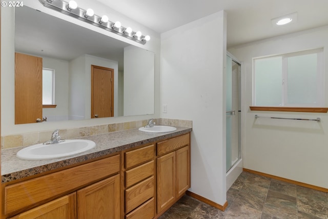 bathroom with a shower with door and vanity