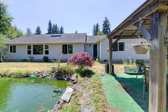 back of property featuring a water view and a yard