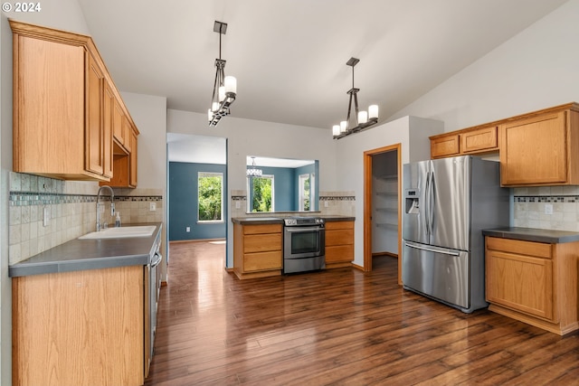 kitchen featuring tasteful backsplash, vaulted ceiling, pendant lighting, sink, and appliances with stainless steel finishes