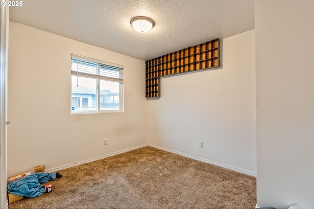 spare room with carpet floors and a textured ceiling