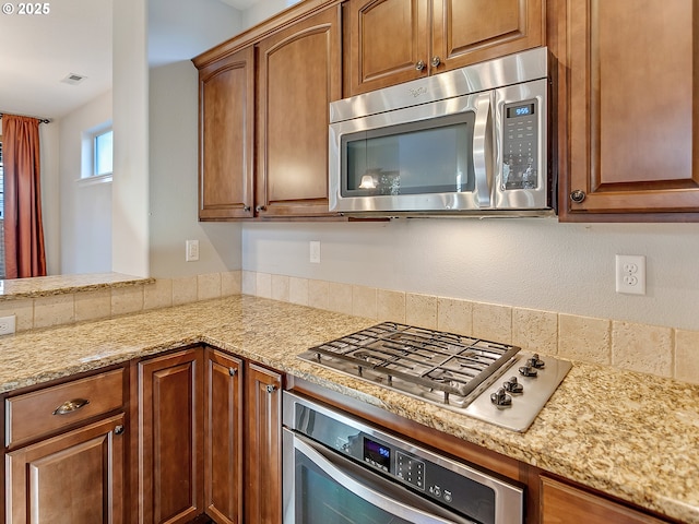 kitchen featuring appliances with stainless steel finishes and light stone countertops