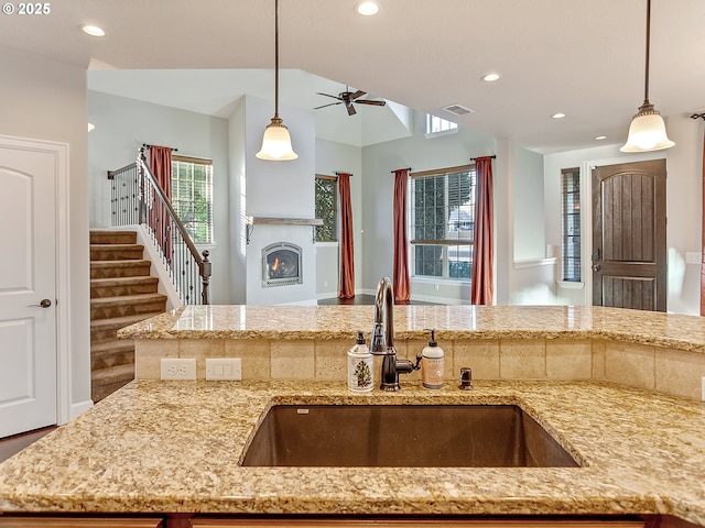 kitchen with sink, decorative light fixtures, and a wealth of natural light