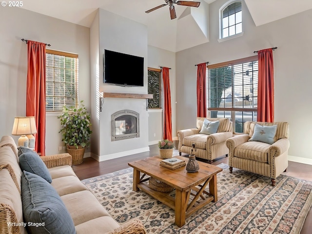 living room with hardwood / wood-style floors, a towering ceiling, and ceiling fan