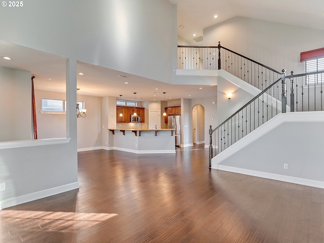 living room with high vaulted ceiling, dark hardwood / wood-style floors, and a chandelier