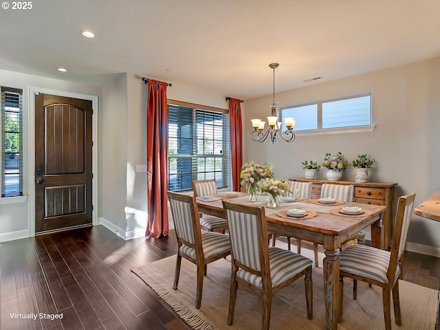 dining room with dark hardwood / wood-style floors and an inviting chandelier