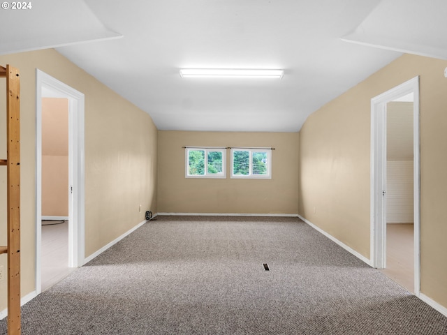 carpeted empty room with lofted ceiling