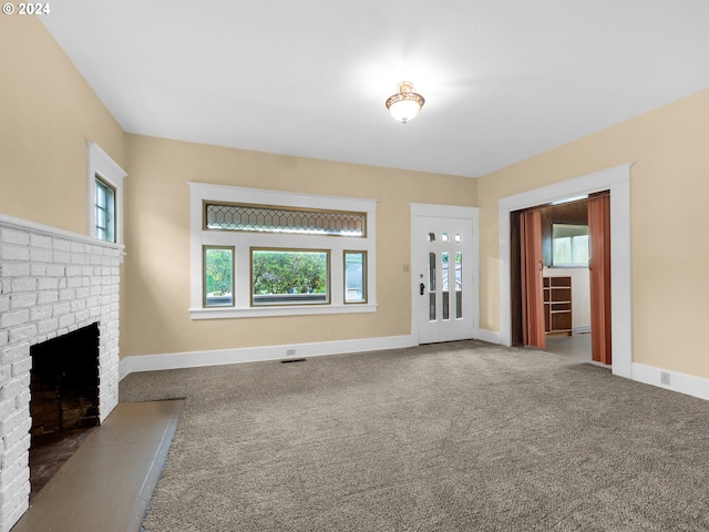 unfurnished living room featuring a fireplace, carpet flooring, visible vents, and baseboards