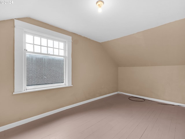 additional living space featuring lofted ceiling and hardwood / wood-style flooring