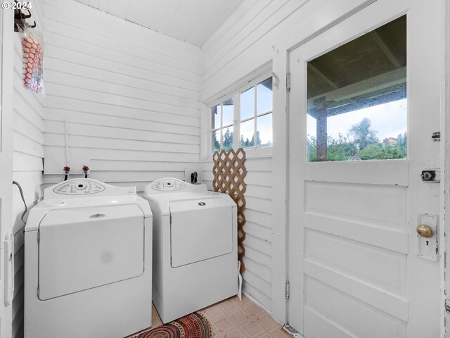 laundry area with separate washer and dryer and light tile patterned floors