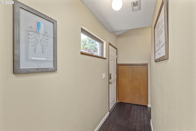 entryway with a textured ceiling and dark hardwood / wood-style flooring