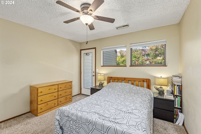 carpeted bedroom with a textured ceiling and ceiling fan