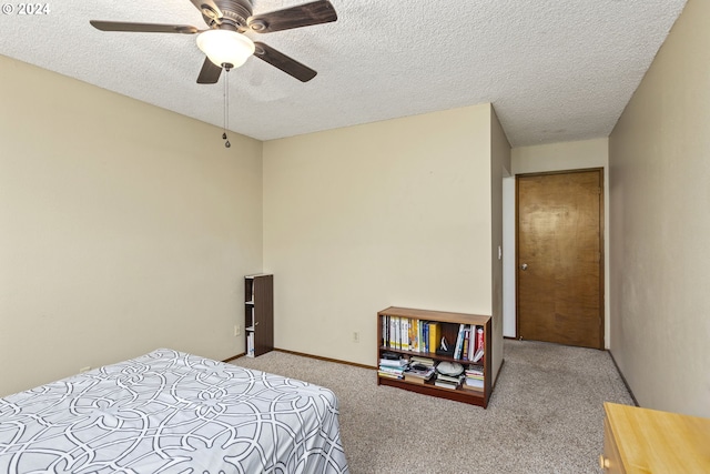 carpeted bedroom with ceiling fan and a textured ceiling