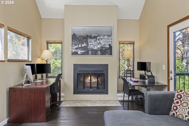 office with light wood-type flooring, a tiled fireplace, and a textured ceiling