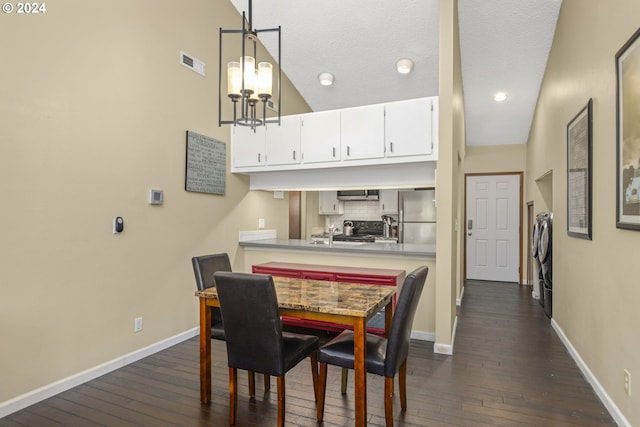 dining area featuring a textured ceiling, a chandelier, high vaulted ceiling, dark hardwood / wood-style floors, and independent washer and dryer