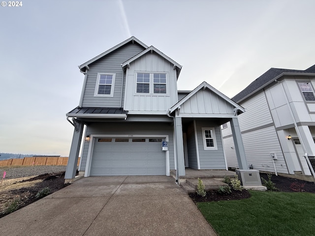 view of front of property featuring a front lawn, cooling unit, and a garage