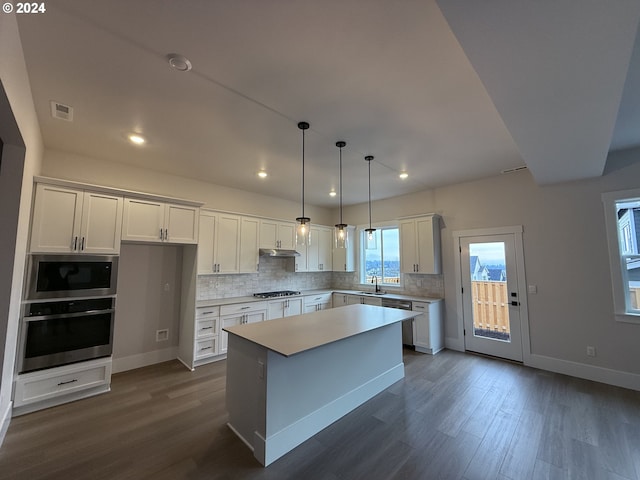 kitchen featuring hanging light fixtures, a center island, stainless steel appliances, white cabinets, and sink