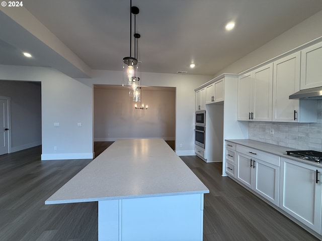 kitchen with decorative light fixtures, white cabinets, a center island, and appliances with stainless steel finishes