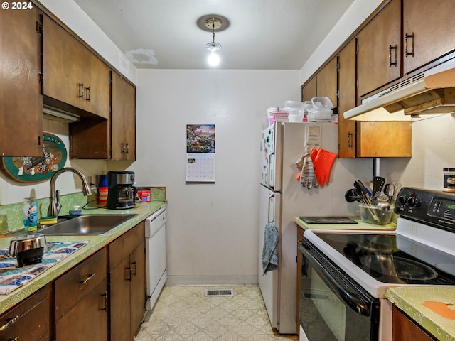 kitchen featuring white appliances, sink, and light tile floors