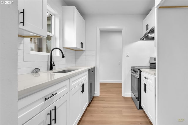 kitchen featuring white cabinetry, sink, light wood-type flooring, and appliances with stainless steel finishes