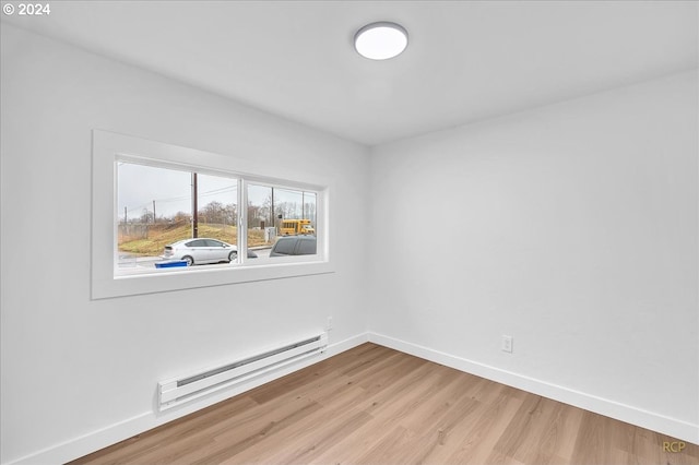 empty room featuring light wood-type flooring and a baseboard radiator