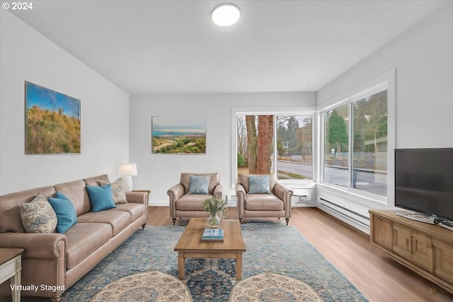 living room with baseboard heating and light hardwood / wood-style flooring