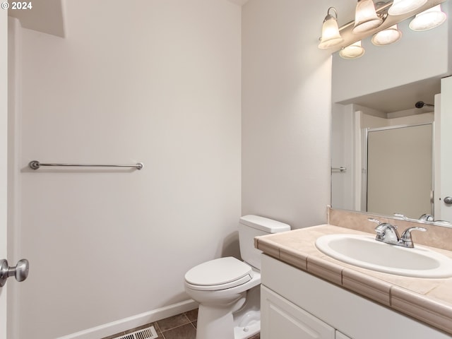 bathroom featuring an enclosed shower, vanity, tile patterned floors, and toilet