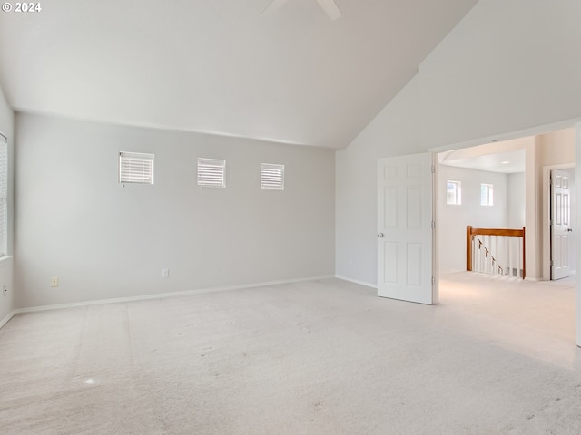 spare room with high vaulted ceiling and carpet flooring