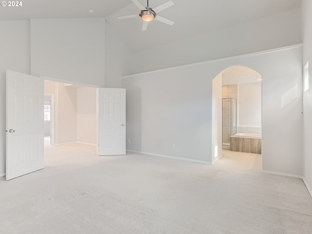 carpeted spare room featuring high vaulted ceiling and ceiling fan