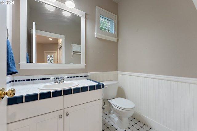 bathroom featuring tile patterned floors, vanity, and toilet