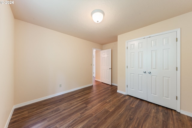 unfurnished bedroom featuring dark hardwood / wood-style floors and a closet