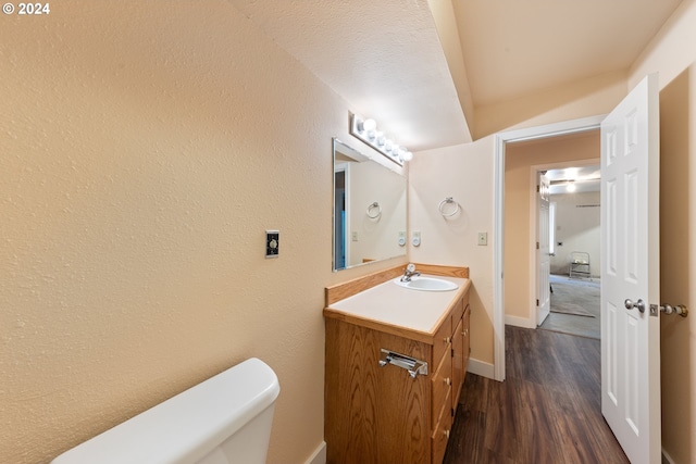 bathroom featuring vanity, wood-type flooring, and toilet