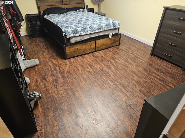 bedroom with dark wood-type flooring