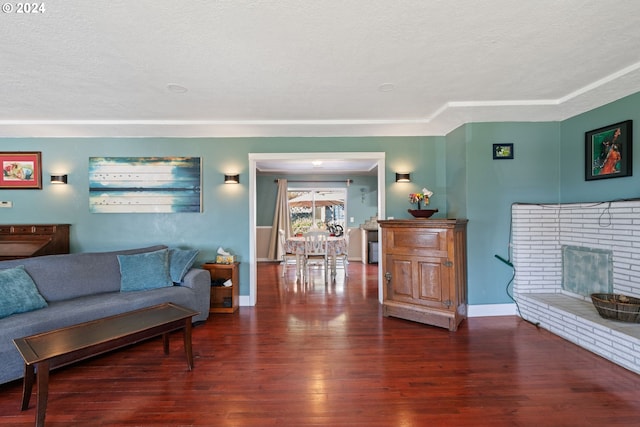 living room featuring a fireplace, a textured ceiling, and dark hardwood / wood-style flooring