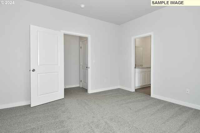 unfurnished bedroom with carpet flooring and ensuite bathroom