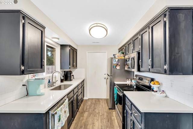 4711 Siesta Ct NE, Salem, OR 97305 - kitchen featuring decorative backsplash, sink, stainless steel appliances, and light hardwood / wood-style flooring