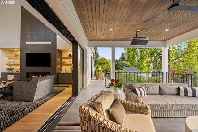 view of patio / terrace featuring ceiling fan and an outdoor living space with a fireplace