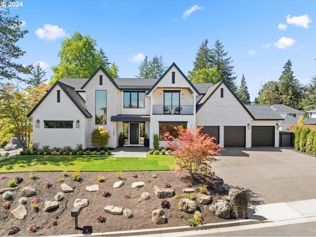 view of front of house with a balcony, a garage, and a front yard