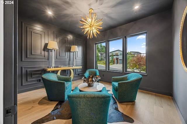 living area with light wood-type flooring and a chandelier