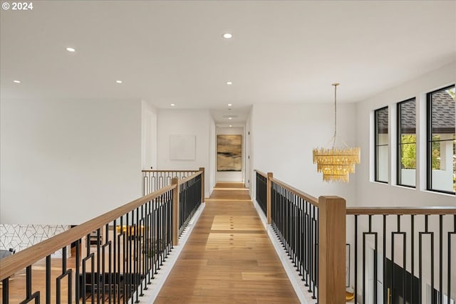 hall featuring an inviting chandelier and light hardwood / wood-style flooring